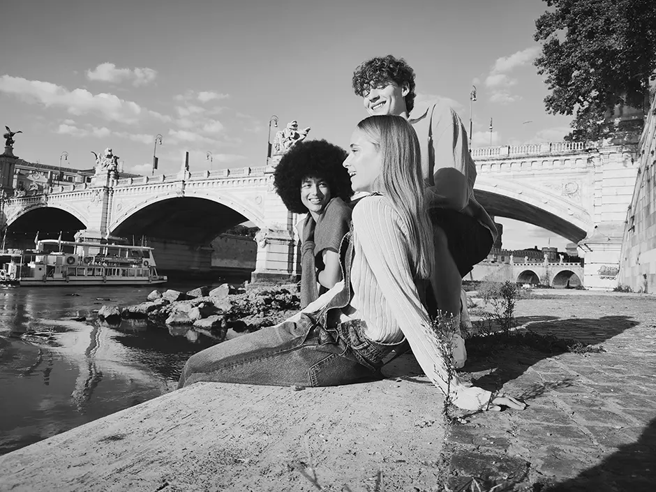 Fiatalok a folyóparton ülnek, fekete-fehér kép